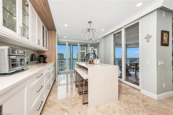 a kitchen with a white cabinets and chandelier