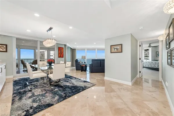 a living room with couches and kitchen view with wooden floor