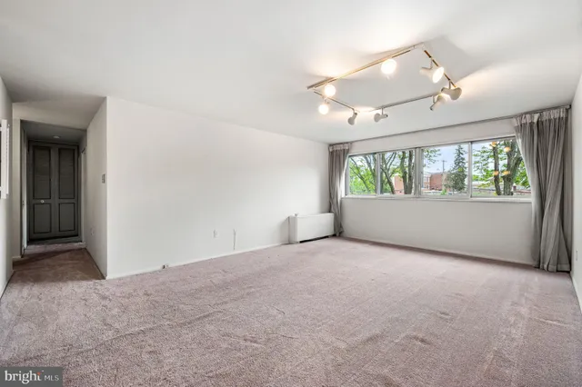 an empty room with windows and ceiling fan