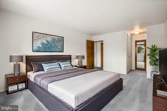 a bedroom with bed and paintings on the wall