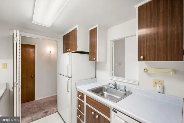 a kitchen with a refrigerator sink and cabinets