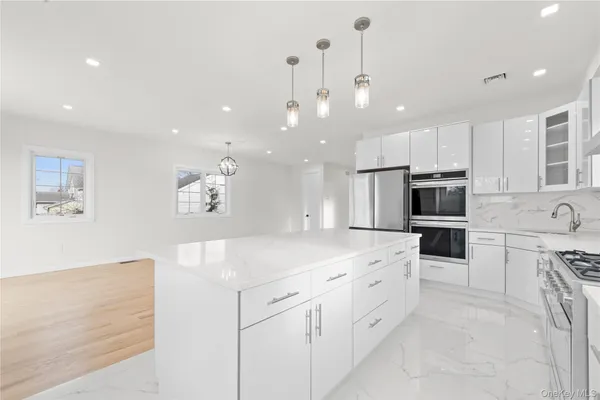 a kitchen with white cabinets and stainless steel appliances
