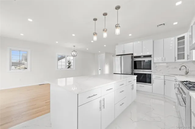 a kitchen with white cabinets and stainless steel appliances