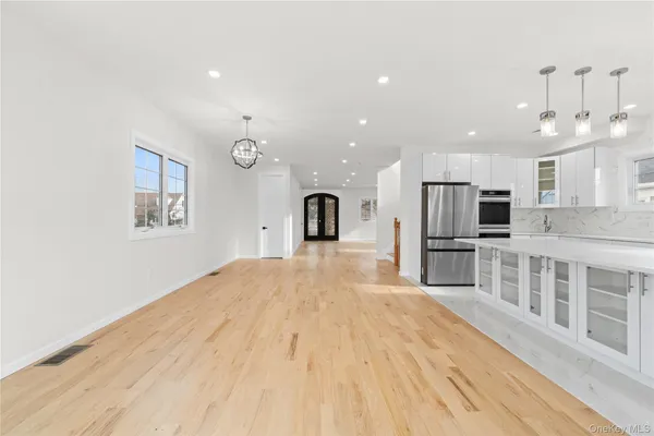 a large kitchen with stainless steel appliances kitchen island a large window a sink and a refrigerator