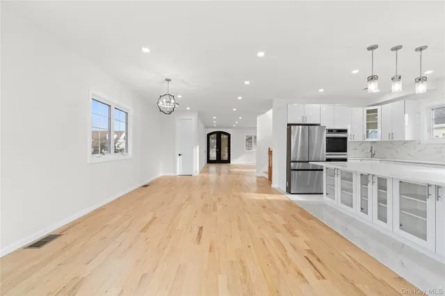 a large kitchen with stainless steel appliances kitchen island a large window a sink and a refrigerator