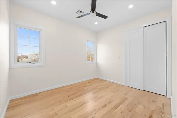 an empty room with windows and fan