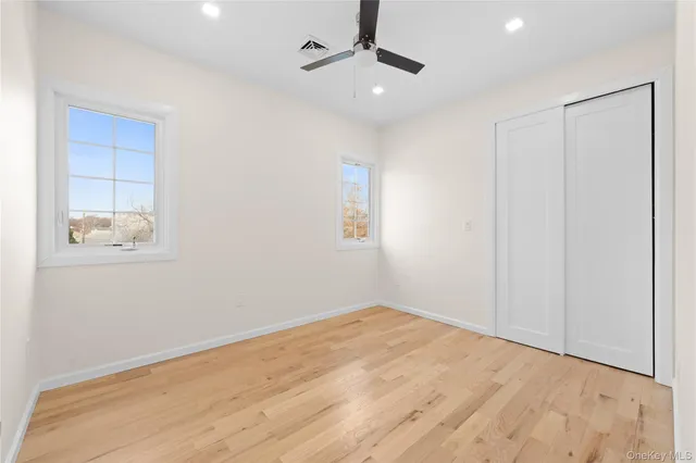 an empty room with windows and fan