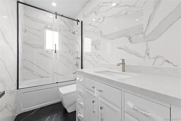 a bathroom with a sink and mirror with toilet