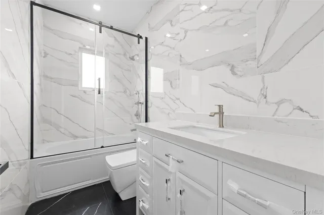 a bathroom with a sink and mirror with toilet