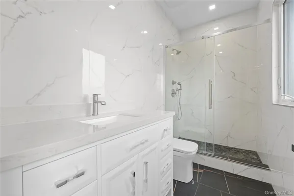 a bathroom with a sink a toilet and shower