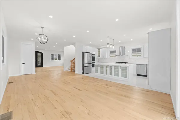 a large white kitchen with a large window and kitchen view