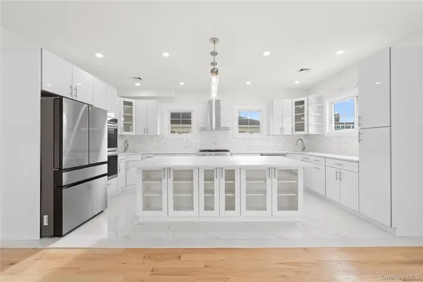 a kitchen with stainless steel appliances granite countertop a refrigerator sink and white cabinets