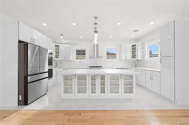 a kitchen with stainless steel appliances granite countertop a refrigerator sink and white cabinets