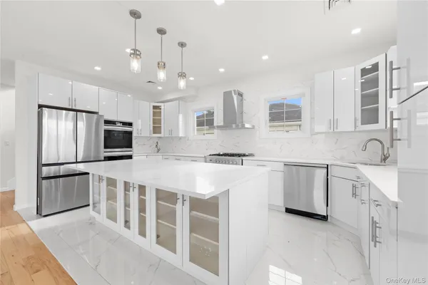 a large kitchen with kitchen island a sink stainless steel appliances and cabinets