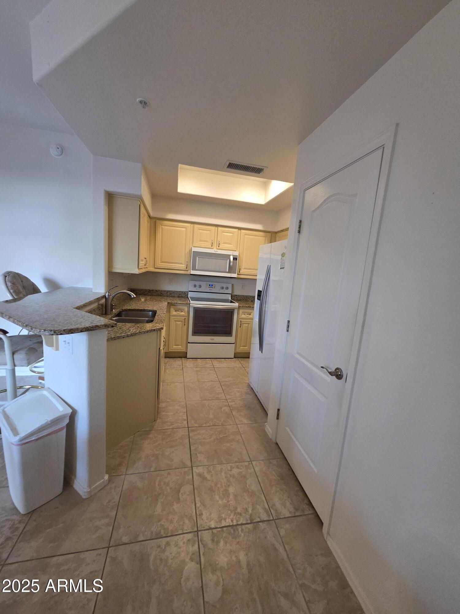 9151 West Greenway Road, Unit 182 Peoria, AZ 85381 - Photo 3 of 19 a kitchen with stainless steel appliances a stove a sink and a refrigerator