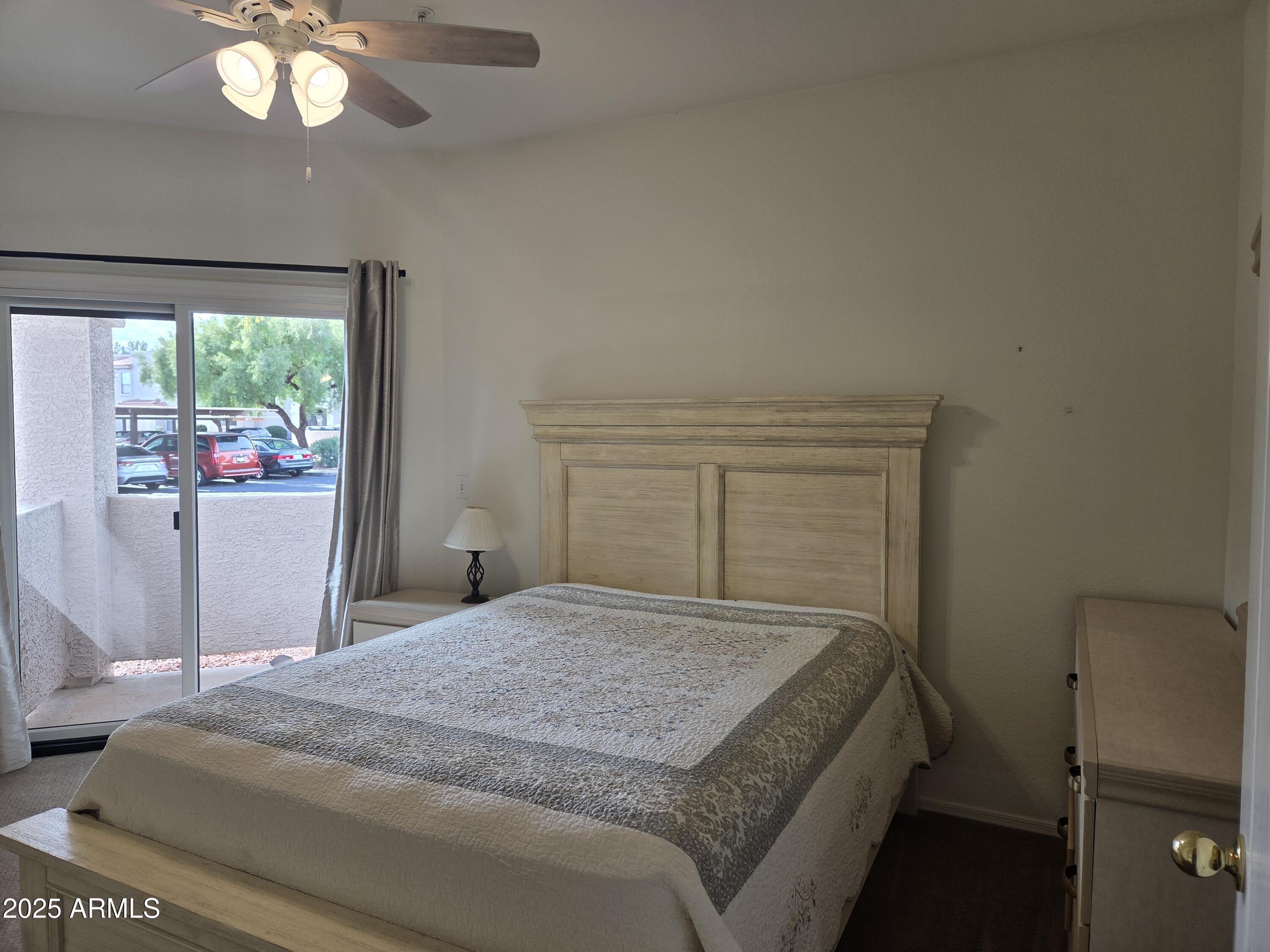9151 West Greenway Road, Unit 182 Peoria, AZ 85381 - Photo 5 of 19 a bedroom with a bed and a chandelier