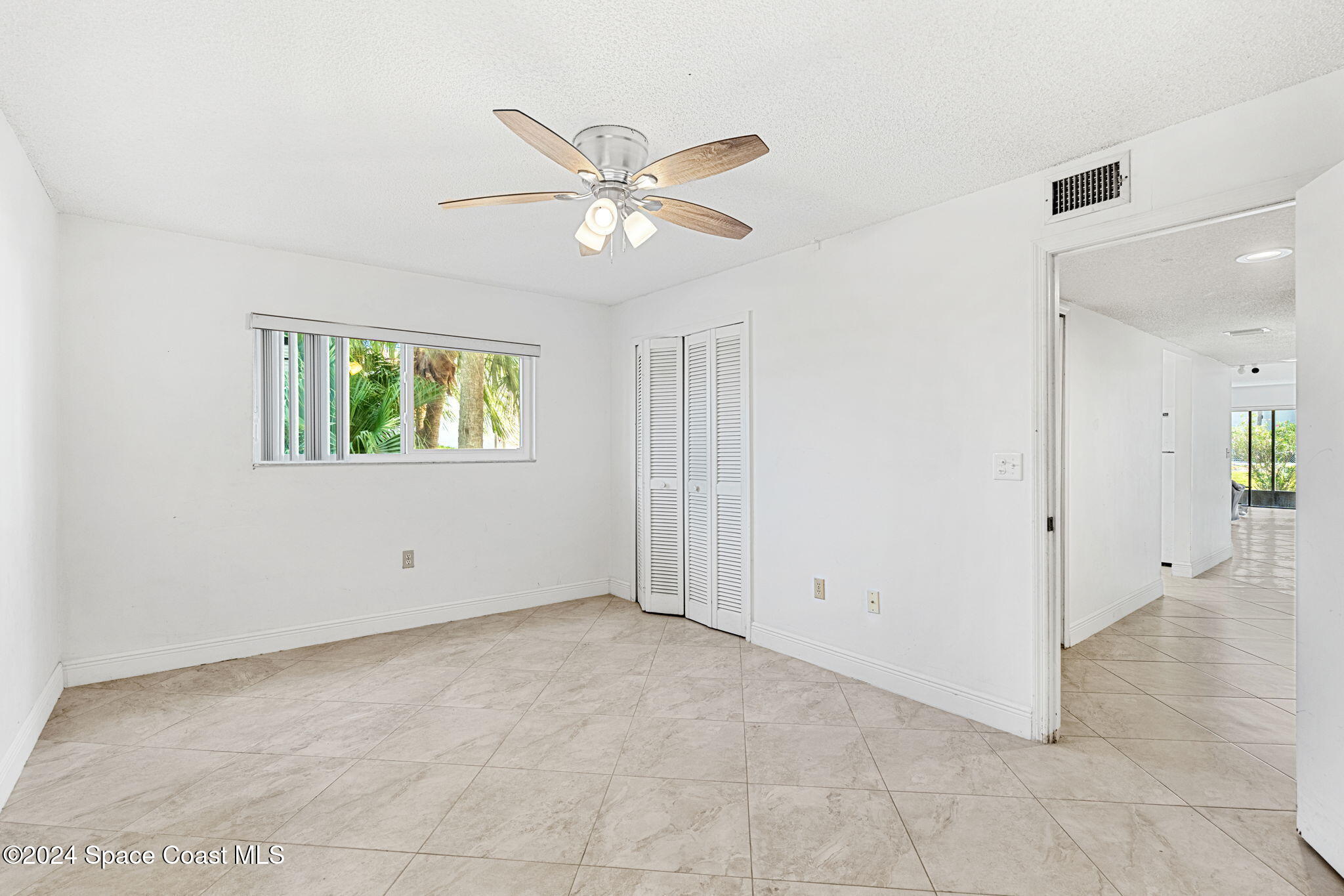 5807 North Atlantic Avenue, Unit 411 Cape Canaveral, FL 32920 - Photo 12 of 31 an empty room with windows and fan
