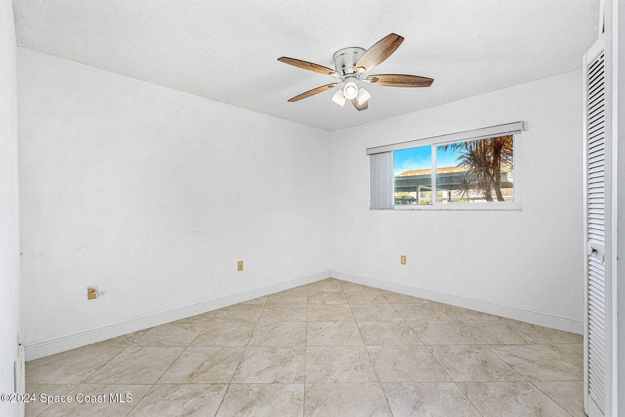 5807 North Atlantic Avenue, Unit 411 Cape Canaveral, FL 32920 - Photo 15 of 31 an empty room with windows and fan