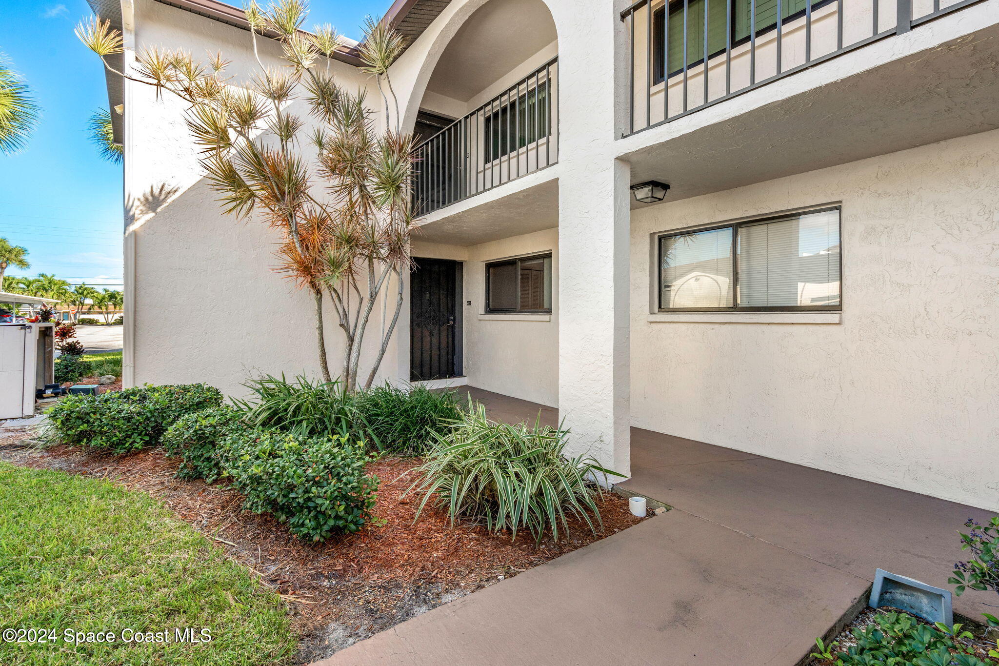 5807 North Atlantic Avenue, Unit 411 Cape Canaveral, FL 32920 - Photo 2 of 31 a front view of a house with a yard