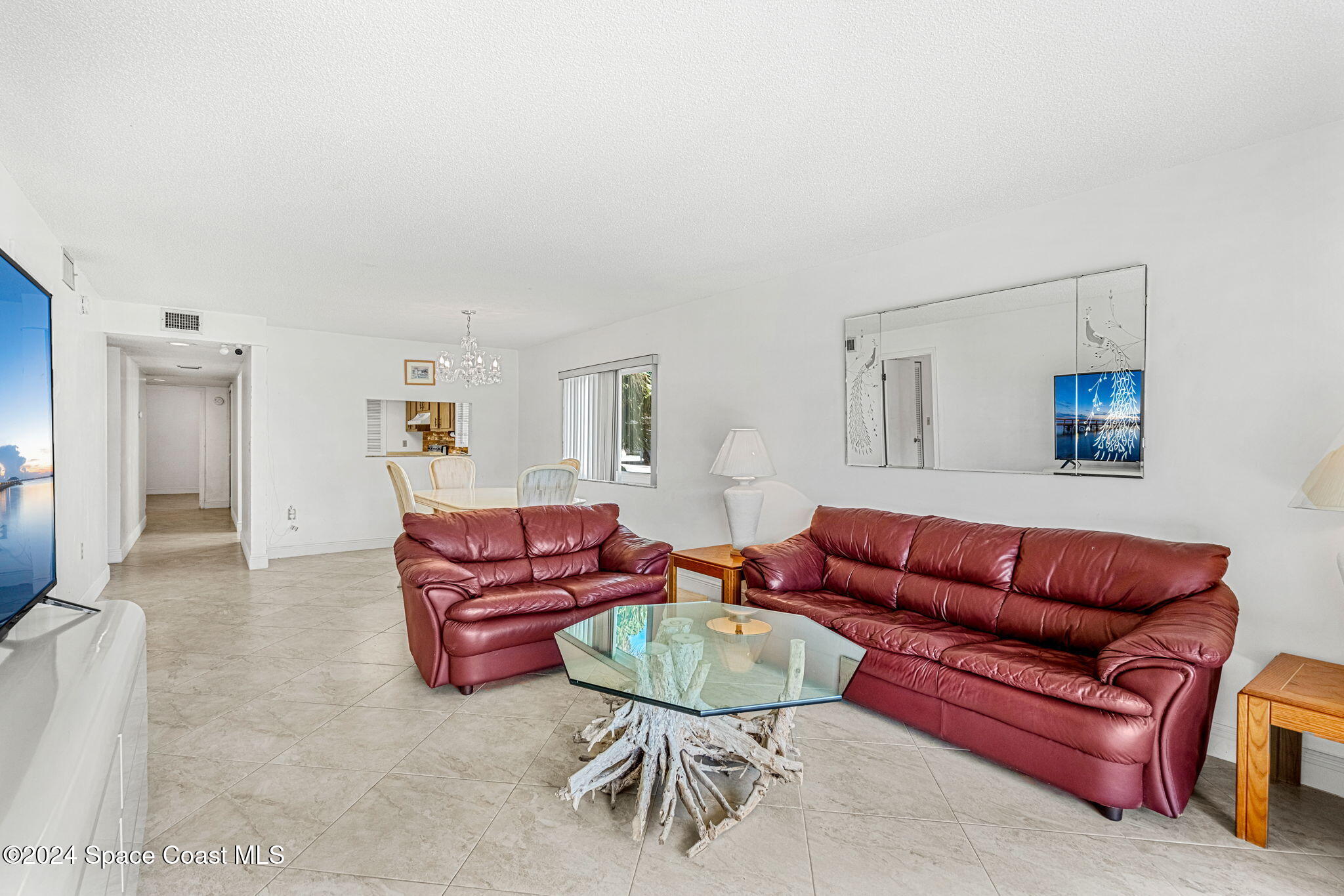 5807 North Atlantic Avenue, Unit 411 Cape Canaveral, FL 32920 - Photo 5 of 31 a living room with furniture a mirror and a couch