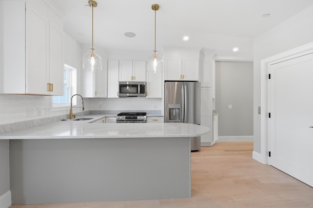 51 West Main Street, Unit 6R Georgetown, MA 01833 - Photo 13 of 40 a large kitchen with stainless steel appliances a refrigerator a sink a center island and a stove