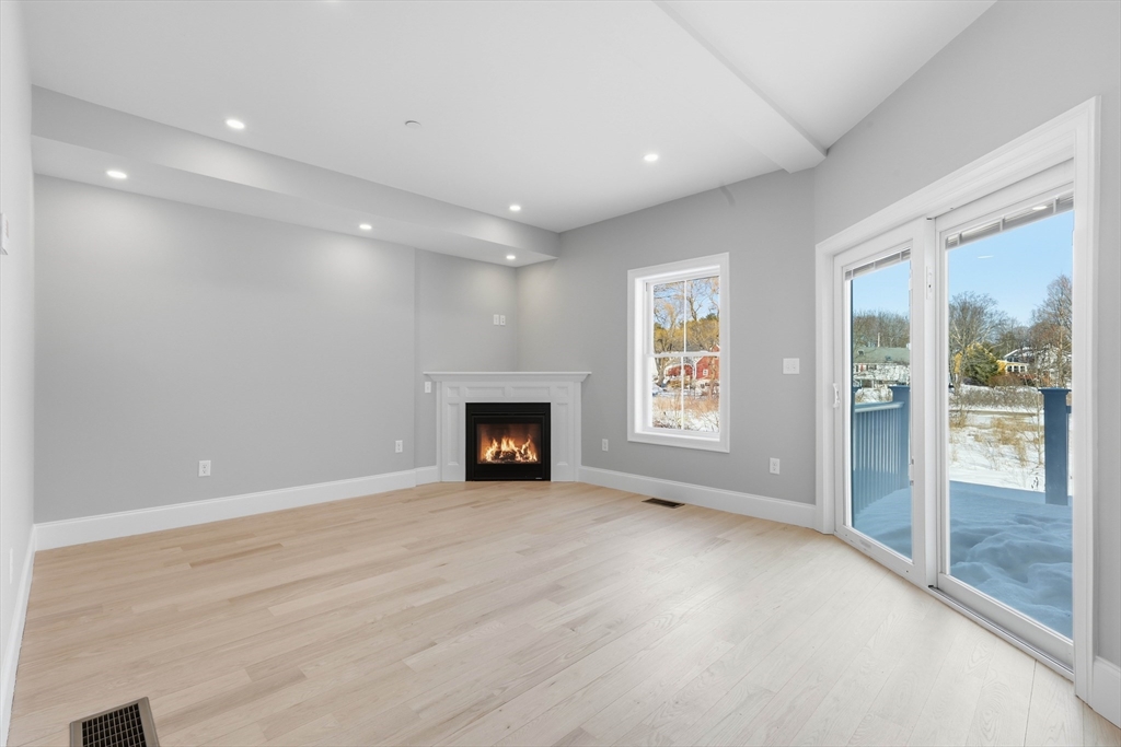 51 West Main Street, Unit 6R Georgetown, MA 01833 - Photo 14 of 40 an empty room with floor to ceiling window and fireplace