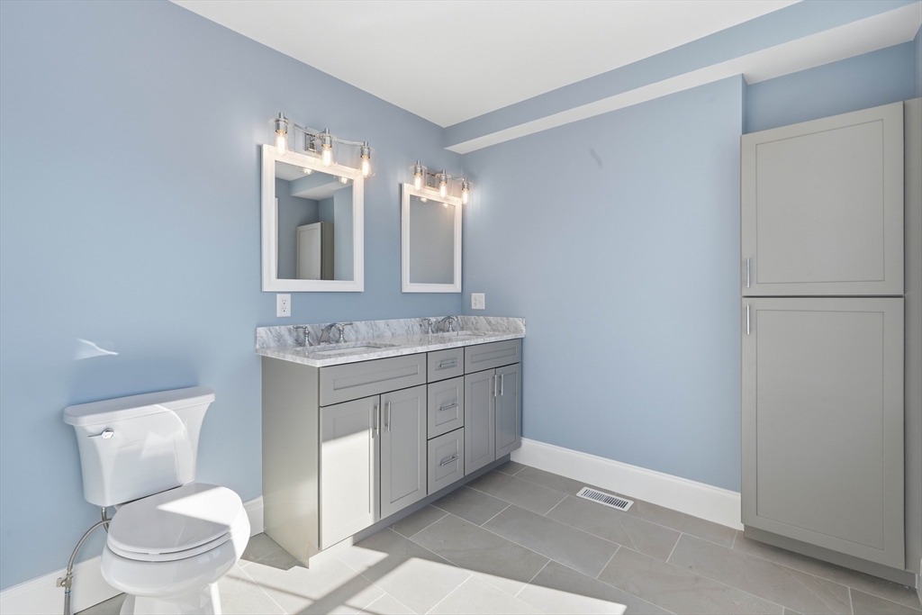 51 West Main Street, Unit 6R Georgetown, MA 01833 - Photo 29 of 40 a bathroom with a granite countertop sink toilet and mirror