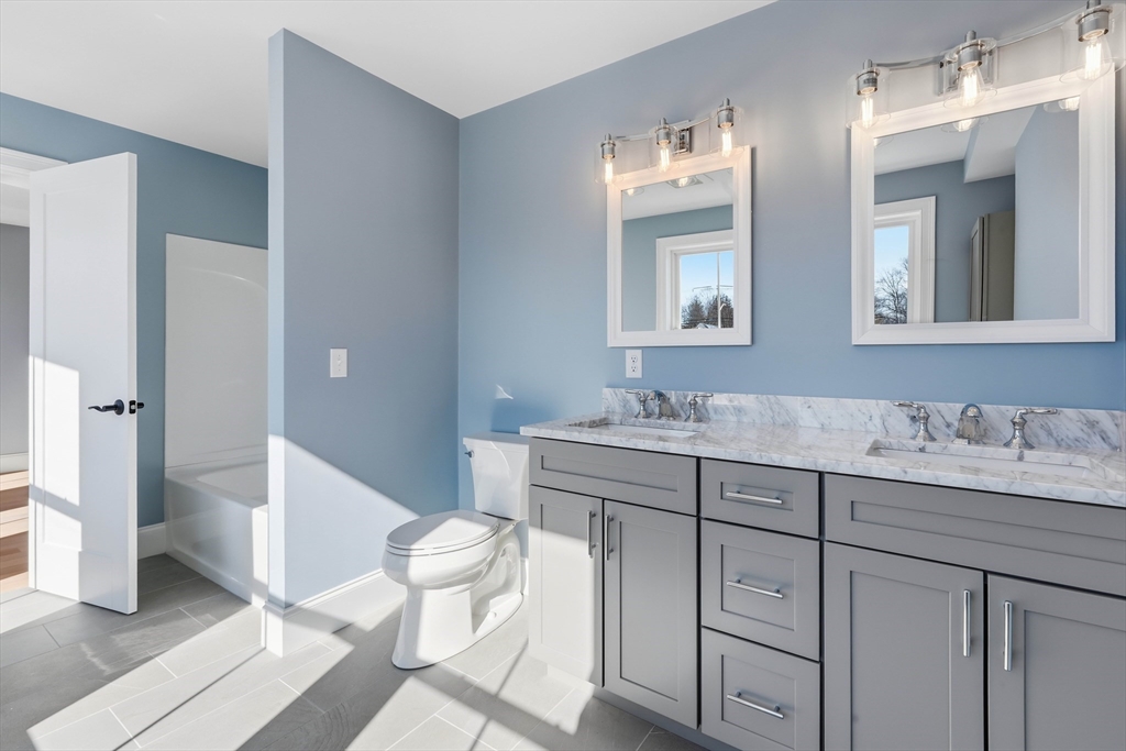 51 West Main Street, Unit 6R Georgetown, MA 01833 - Photo 30 of 40 a bathroom with a granite countertop sink mirror and toilet