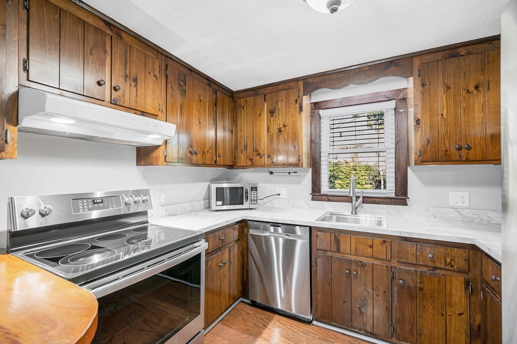 163 Water Street Framingham, MA 01701 - Photo 12 of 37 a kitchen with wooden cabinets stove top oven and sink