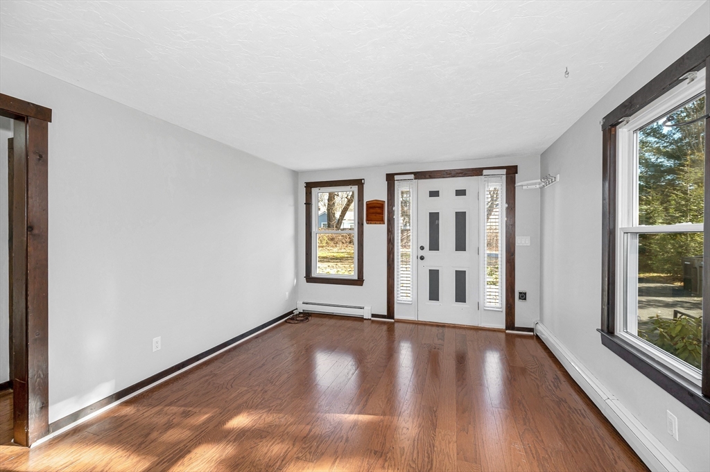 163 Water Street Framingham, MA 01701 - Photo 5 of 37 a view of an empty room with wooden floor and a window