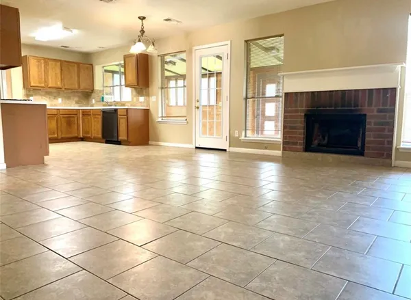 a large kitchen with granite countertop a stove a oven a counter space and cabinets