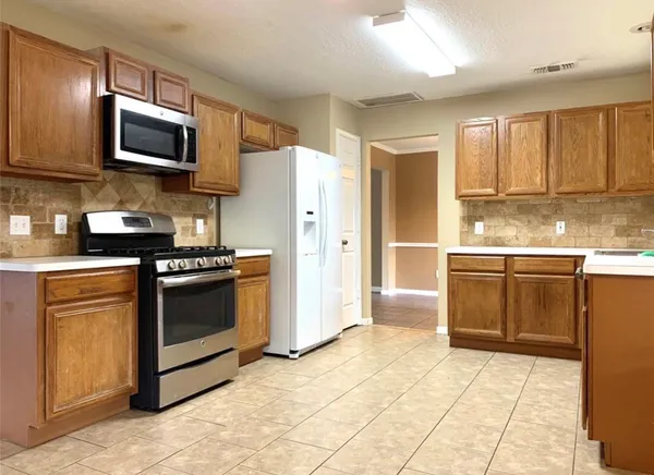 a kitchen with stainless steel appliances granite countertop a refrigerator stove and microwave