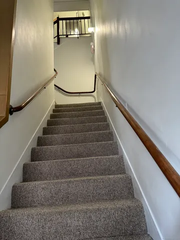 a view of staircase with lots of frames on wall