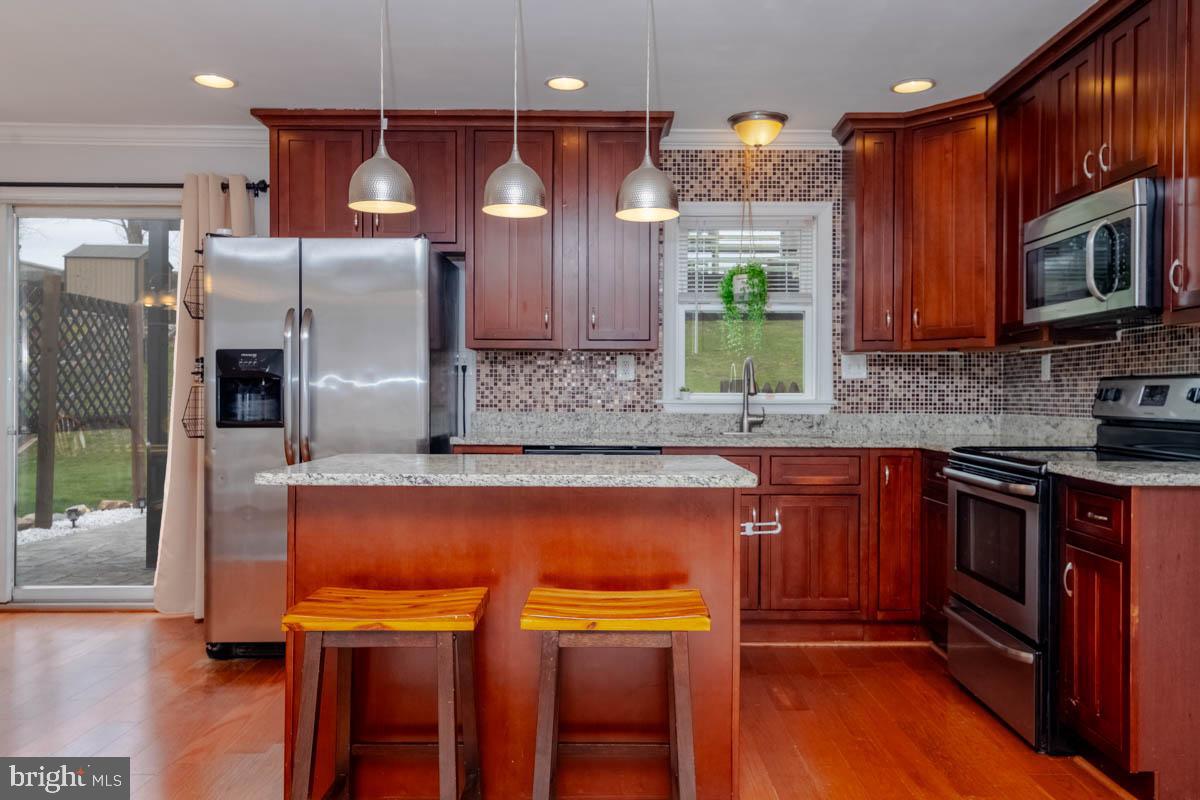 414 Enfield Road Joppa, MD 21085 - Photo 11 of 42 a kitchen with stainless steel appliances granite countertop a refrigerator and a stove top oven