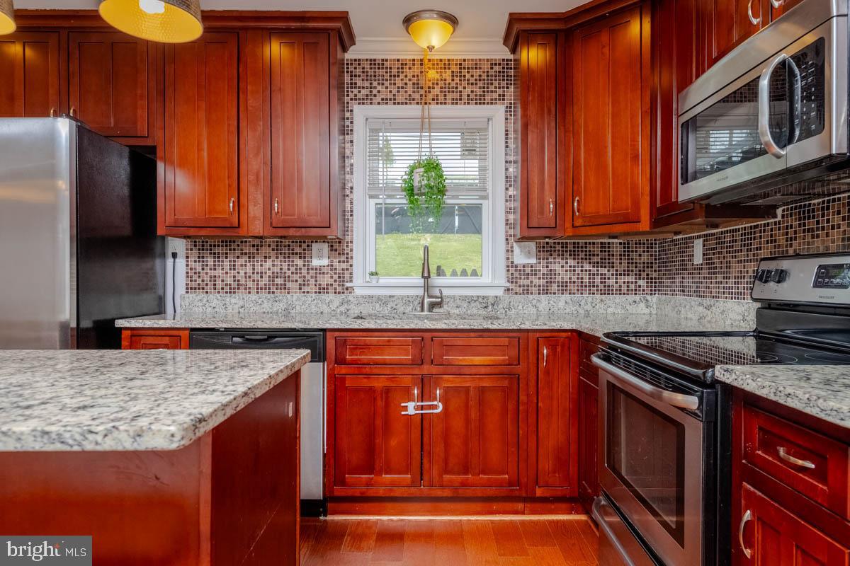 414 Enfield Road Joppa, MD 21085 - Photo 12 of 42 a kitchen with stainless steel appliances granite countertop a stove a sink and a microwave
