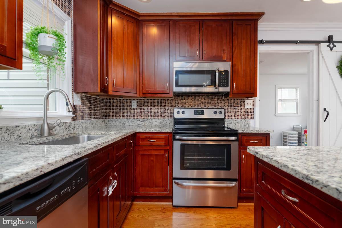 414 Enfield Road Joppa, MD 21085 - Photo 13 of 42 a kitchen with stainless steel appliances granite countertop a sink stove and microwave
