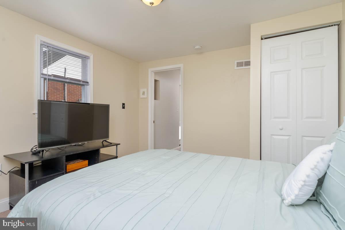 414 Enfield Road Joppa, MD 21085 - Photo 29 of 42 a bedroom with a bed and a flat tv screen on wall