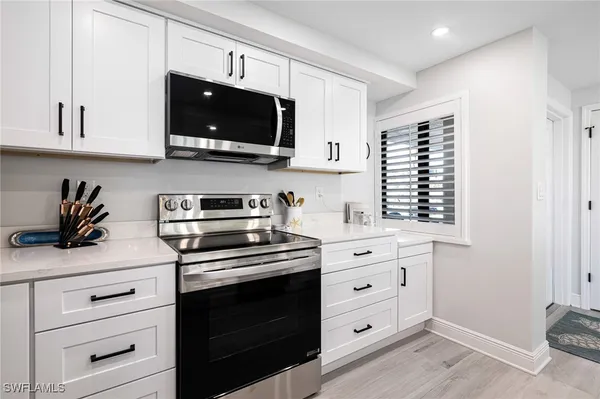 a kitchen with white cabinets and stainless steel appliances