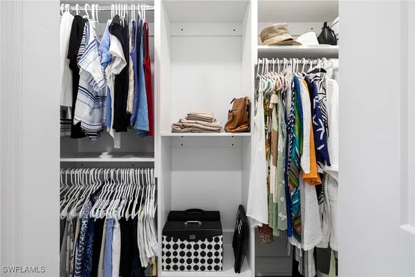 a view of walk in closet with clothes and shoes