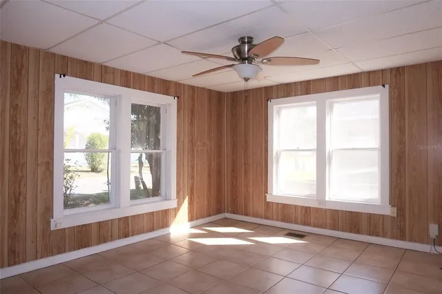 a view of an empty room and window ceiling fan