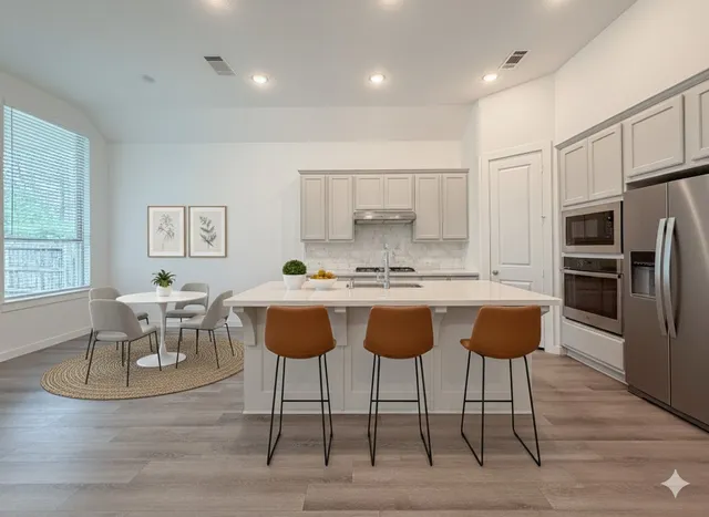 a kitchen with stainless steel appliances granite countertop a stove a sink a table and chairs