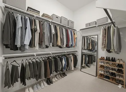 a view of walk in closet with clothes and shoes