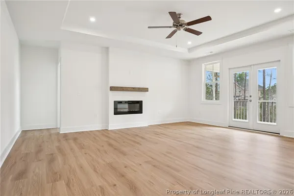 an empty room with a window and a ceiling fan
