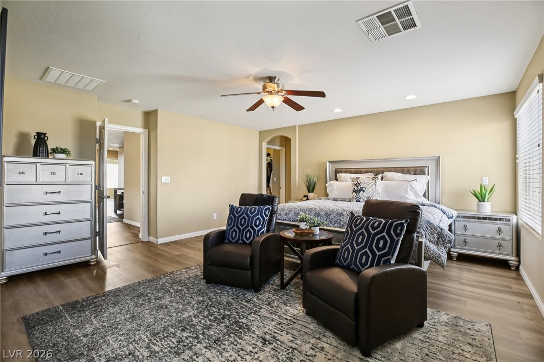 3957 East Carla Ann Road North Las Vegas, NV 89081 - Photo 18 of 35 Bedroom with dark wood-type flooring, ceiling fan, a walk in closet, recessed lighting, and arched walkways