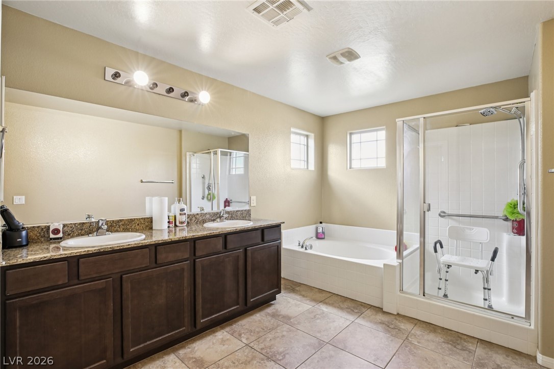 3957 East Carla Ann Road North Las Vegas, NV 89081 - Photo 21 of 35 Bathroom featuring a bath, a stall shower, double vanity, and light tile patterned floors