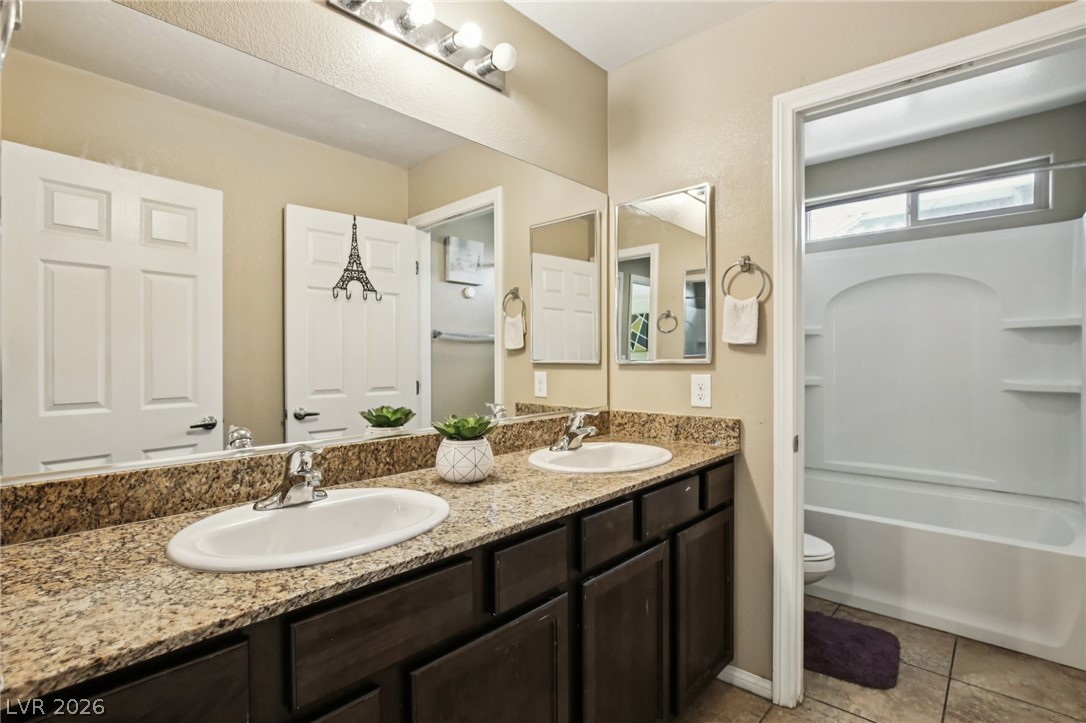 3957 East Carla Ann Road North Las Vegas, NV 89081 - Photo 25 of 35 Full bath featuring double vanity, tub / shower combination, and light tile patterned floors