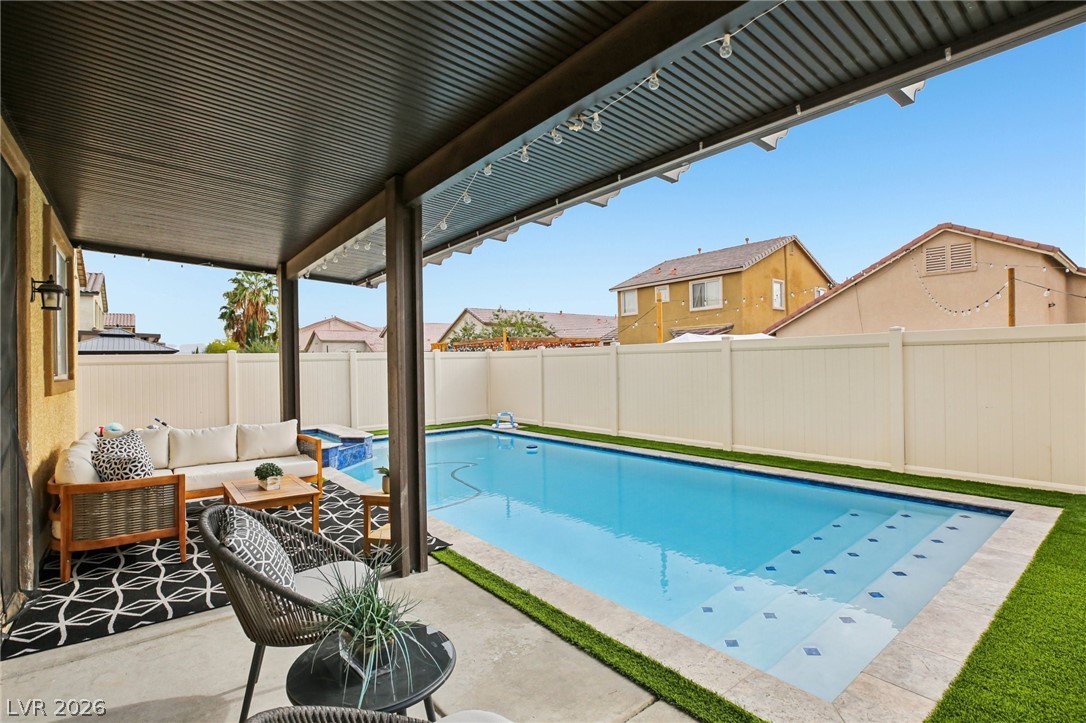 3957 East Carla Ann Road North Las Vegas, NV 89081 - Photo 31 of 35 View of swimming pool with outdoor seating, patio surround, a pergola, and a fenced backyard