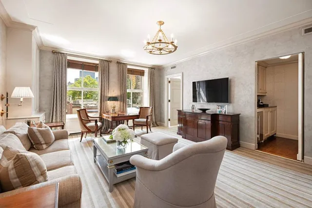 a living room with furniture a flat screen tv and a large window