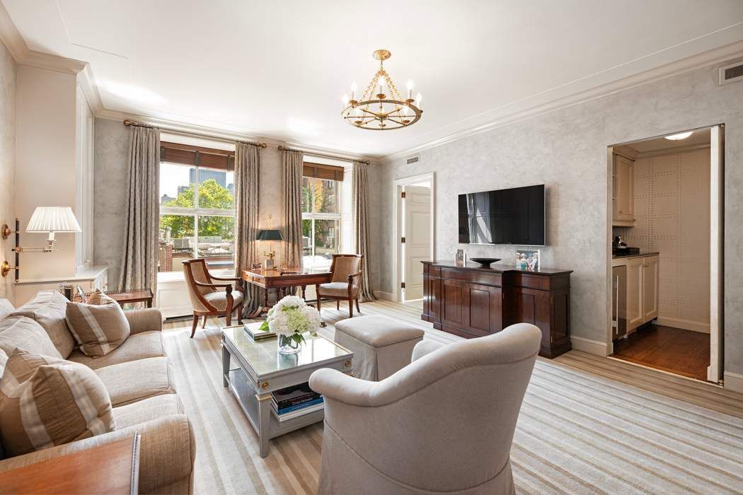 740 Park Avenue, Unit 6/7D Manhattan, NY 10021 - Photo 12 of 19 a living room with furniture a flat screen tv and a large window