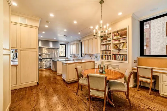 a dining room with stainless steel appliances kitchen island granite countertop a dining table chairs and chandelier